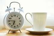Wecker auf 06:45 und weiße Tasse
