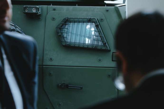 M&auml;nner in Anz&uuml;gen vor Panzer