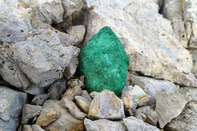 Grün oxidiertes Kupfererz vor Geröll