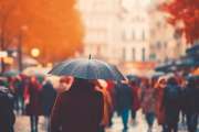 the flow of people with umbrellas on a pedestrian street autumn weather in the city