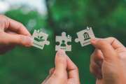 ESG Concepts on Environment, Society and Governance In hand holding puzzle pieces that come together to complete the words ESG and the icon solving environmental problems.