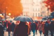 the flow of people with umbrellas on a pedestrian street autumn weather in the city