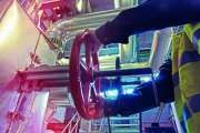 industrial factory worker turning red wheel of valve