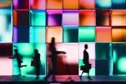Night render of a building made of glowing cubes, people walking past