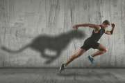 Strong athletic man sprinter, running on dark wall background wearing in sportswear. Sport and fitness motivation