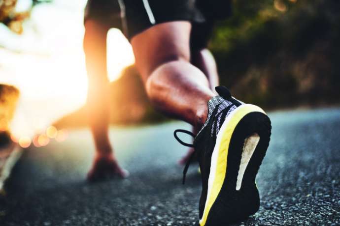 Low angle shot of a man out exercising on a tarmac road