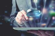 Businessman examines an infected tablet with a magnifying glass. Concept of internet security