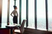 Rearview shot of an attractive young businesswoman standing with her hands on her hips in the office