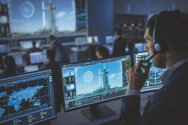 Flight Director Counts Down the Seconds Before Space Rocket Launch. Team in Mission Control Witness Successful Lift Off. Flight Control Employees Sit in Front of Computers and Monitor the Mission.