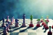 A chessboard features creatively painted pieces in red, white, and blue, with a dove soaring above, illuminated by soft light
