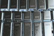 A stack of solid platinum ingots on an isolated dark background - 3D render