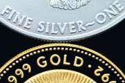 Macro image of a gold coin placed above a silver coin on a black background. The words Gold And Fine Silver are clearly visible.