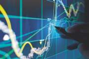 A business person tracking the technical movement of a stock chart on a computer screen.