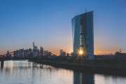 Frankfurt am Main, Germany -May 13th 2019. 
European Central Bank (ECB) Tower  and Skyline with a orange-blue Sunsetreflected on the water of the Main River. The sun shines through the ECB towers