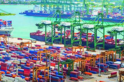 Aerial panorama of cargo ships in Singapore industrial port harbor by pier with freight cranes and goods containers, seacsape at background