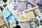 British pound money bills pile on table. United Kingdom banknotes of GBP currency close up. Concept of business, economy and investment in United Kingdom.