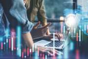 Group of business people working at modern office.Technical price graph and indicator, red and blue candlestick chart and stock trading computer screen background. Double exposure. Traders analyzing data.