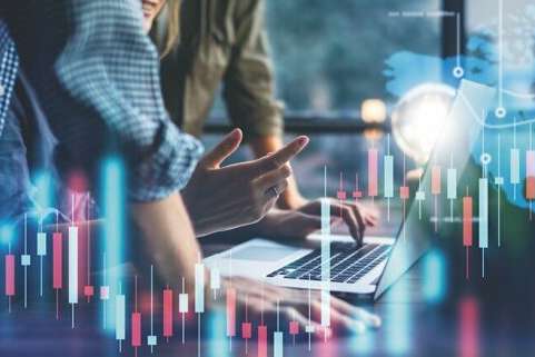 Group of business people working at modern office.Technical price graph and indicator, red and blue candlestick chart and stock trading computer screen background. Double exposure. Traders analyzing data.