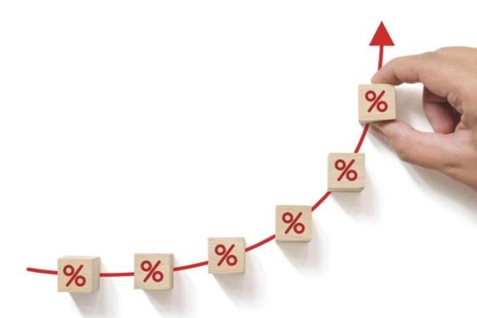 Interest rate financial and mortgage rates concept. Hand putting wood cube block increasing with icon percentage symbol upward direction