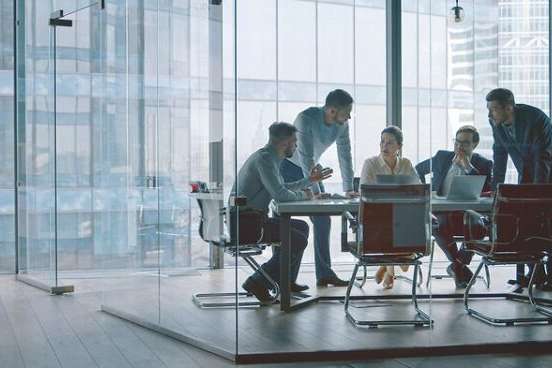 Group of business people working with technology at a meeting in a conference room in office