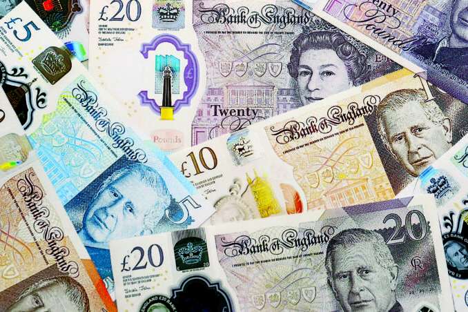 British pound money bills pile on table. United Kingdom banknotes of GBP currency close up. Concept of business, economy and investment in United Kingdom.