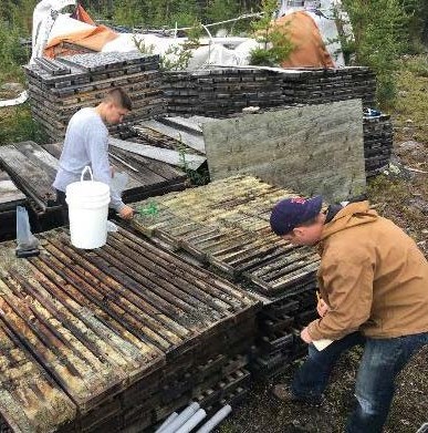 A group of men outside with buckets and wood pallets
AI-generated content may be incorrect.